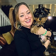 Dallas Lee joined the competition — help win amazing prizes! woman, dog, puppy, smiling, portrait, indoor, living_room, person, happy, black_clothing, bracelet, earrings, cute, pet, home_decor, sofa, cushion, blonde_hair, holding, face