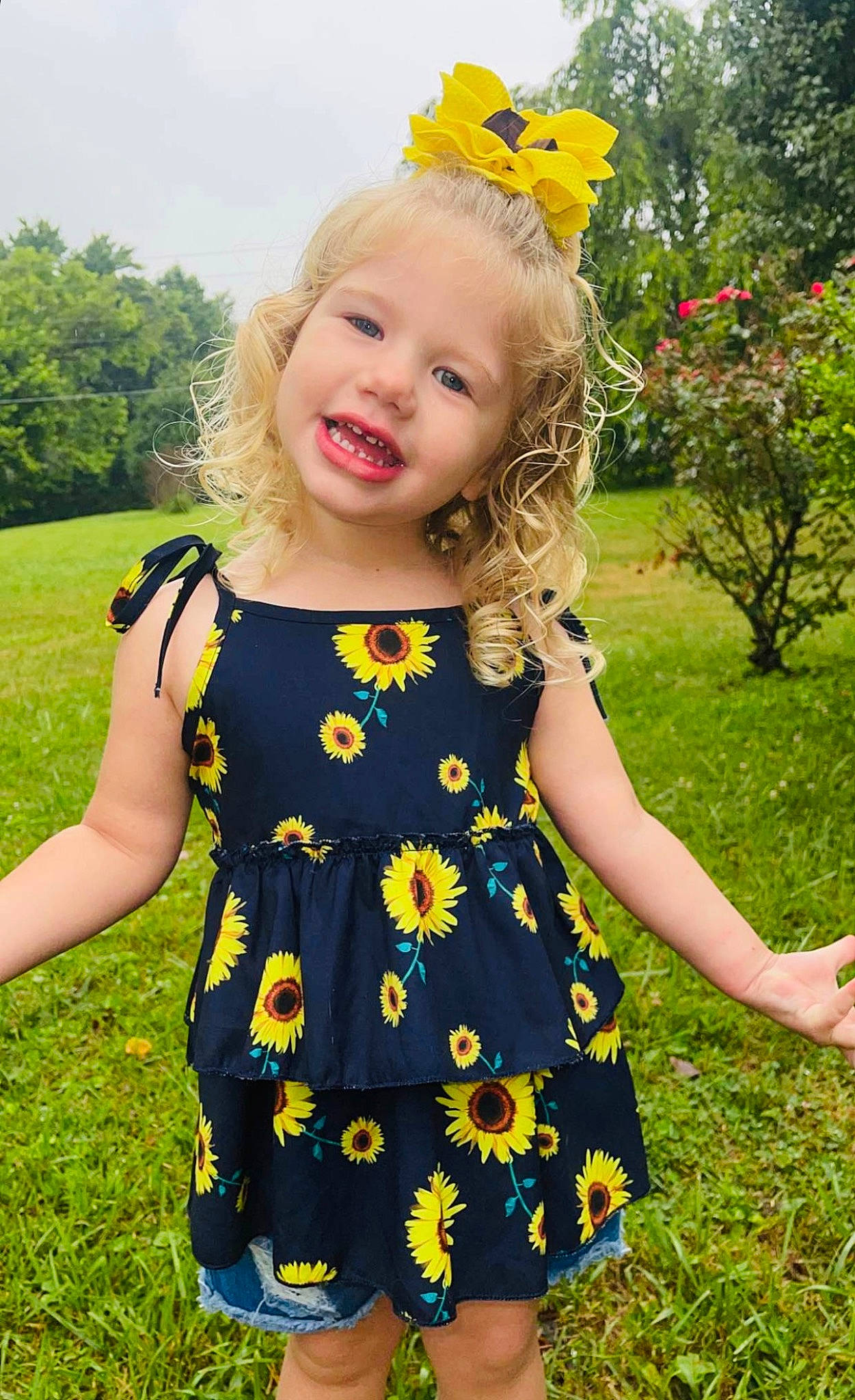 Hadleigh is registered to the contest to win money with this photo: baby_toddler_clothing, botany, clothing, day_dress, dress, facial_expression, grass, green, hairstyle, happy, joy, leaf, nature, one_piece_garment, people_in_nature, person, pink, plant, sleeve, smile