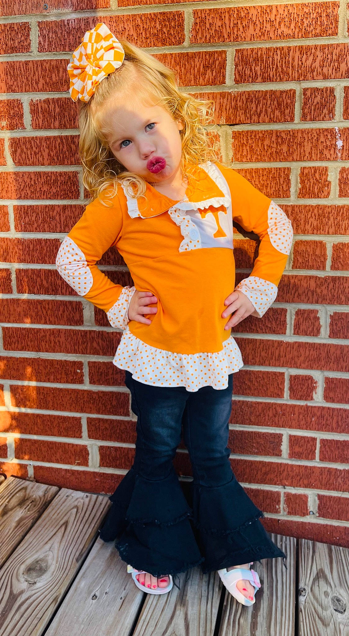 Hadleigh is registered to the contest to win money with this photo: baby_toddler_clothing, brick, brickwork, clothing, eye, face, hair, hairstyle, happy, knee, leg, orange, person, pink, sleeve, sock, standing, thigh, trunk, waist
