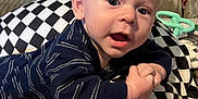 Andrew Mason joined the competition — help win amazing prizes! baby, infant, child, face, eyes, mouth, hand, pillow, checkered, striped_clothing, couch, blanket, toy, indoor, closeup, curious, expression, skin, head, person