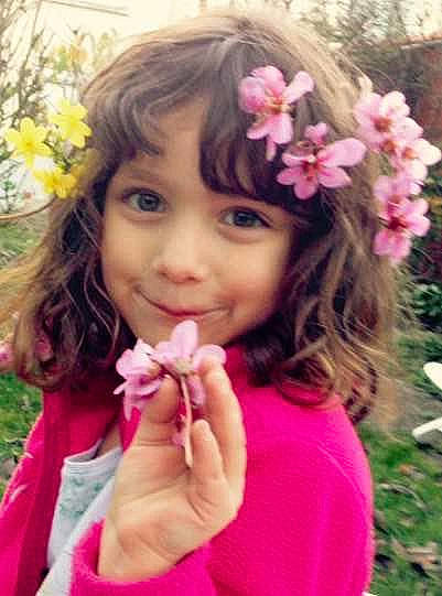 Nina participe au concours pour gagner de l'argent avec cette photo : blossom, brown_hair, cheek, child, child_model, fashion_accessory, finger, flower, gesture, hair, hair_accessory, hairstyle, headgear, lip, long_hair, person, petal, pink, plant, spring