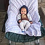 Sebastian Milan a rejoint le concours — aidez-le/la à gagner de superbes lots ! baby, child, hoodie, blanket, chair, cushion, pattern, giraffe_print, brown_shirt, outdoor, stone_wall, wooden_door, paving_stones, footwear, socks, cute, infant, portrait, seated, clothing