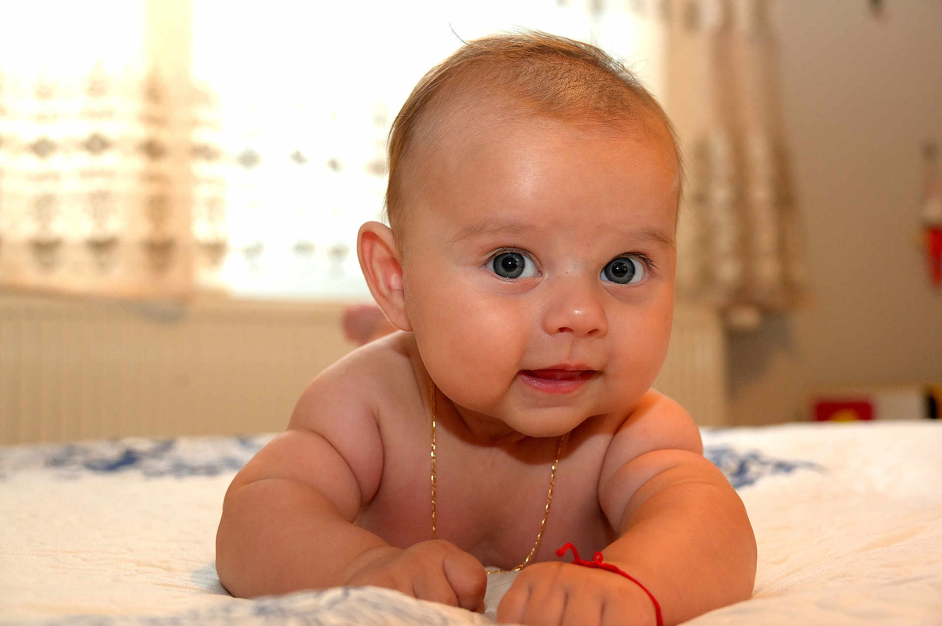Sebastian Milan a rejoint le concours — aidez-le/la à gagner de superbes lots ! baby, infant, face, eyes, skin, arm, hand, bed, blanket, jewelry, necklace, bracelet, indoors, curtains, person, cute, chubby, expression, portrait, child