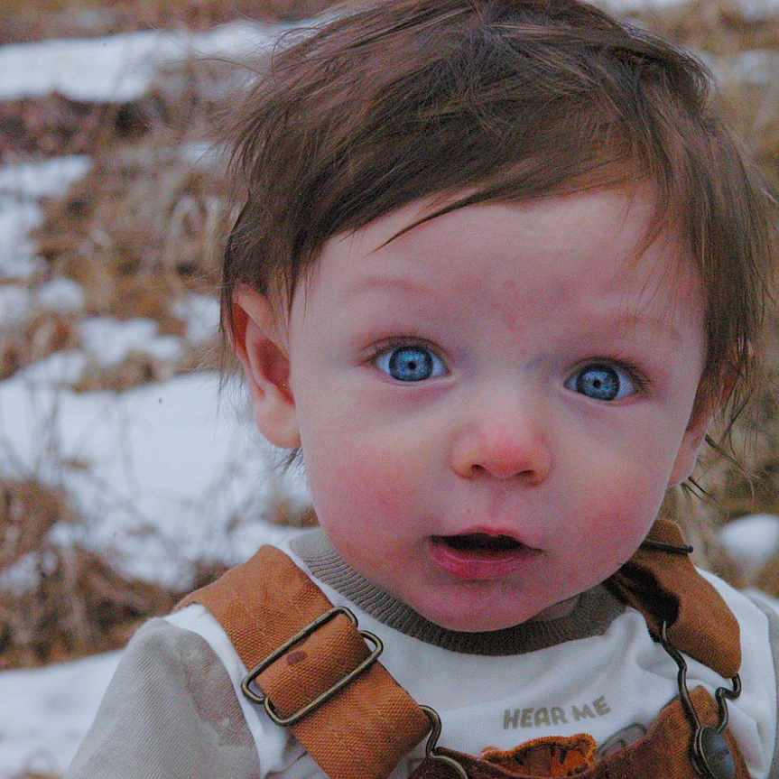 Corvus is registered to the contest to win money with this photo: accessories, baby, bodypart, clothing, coat, face, finger, frown, hand, happy, head, nature, outdoors, person, photography, portrait, sad, smile, snow, strap