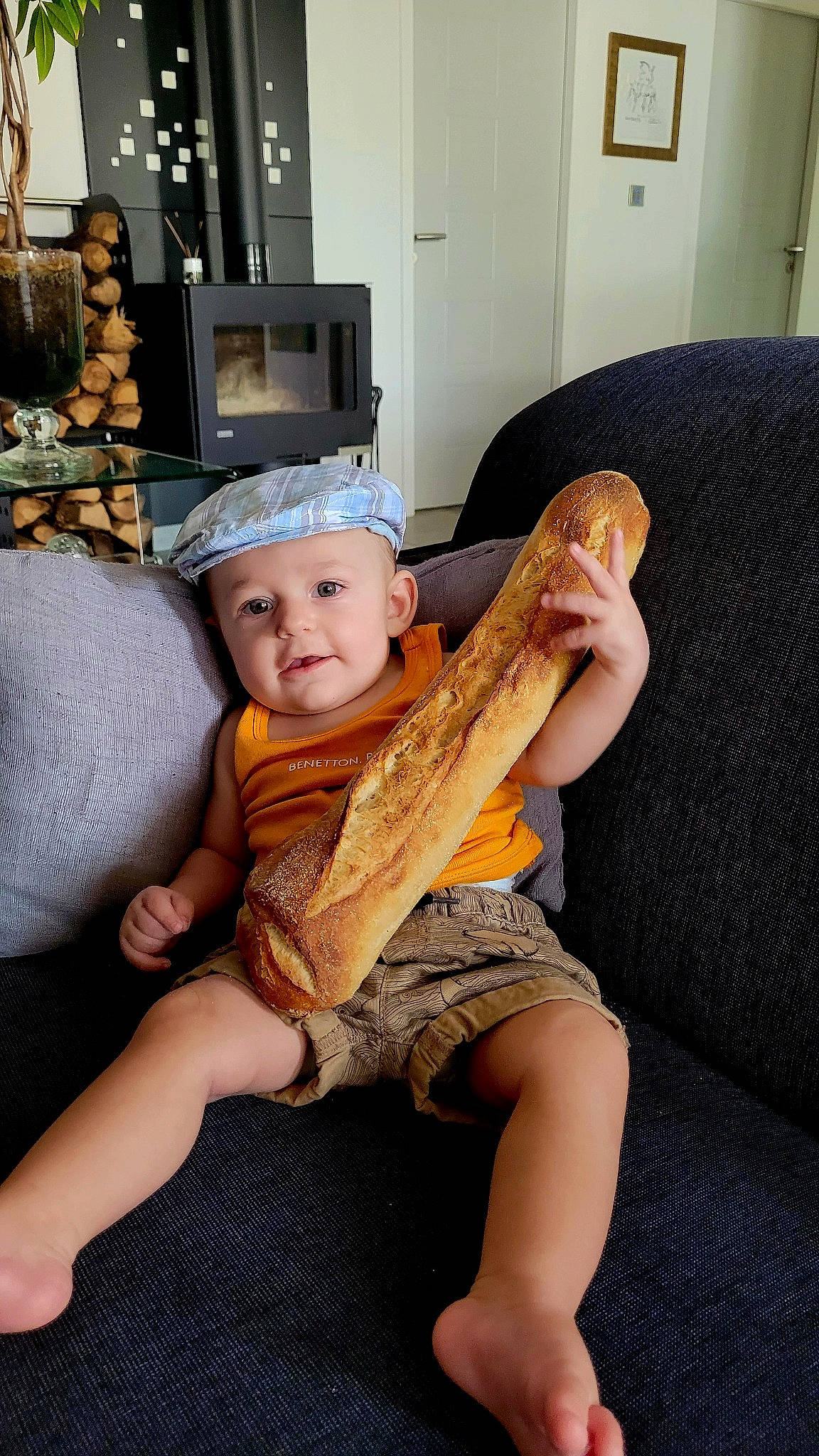 Rafael participe au concours pour gagner de l'argent avec cette photo : baby, baby_toddler_clothing, child, comfort, couch, elbow, flooring, fun, hat, headwear, human_leg, knee, lap, leg, person, picture_frame, room, sitting, tableware, thigh