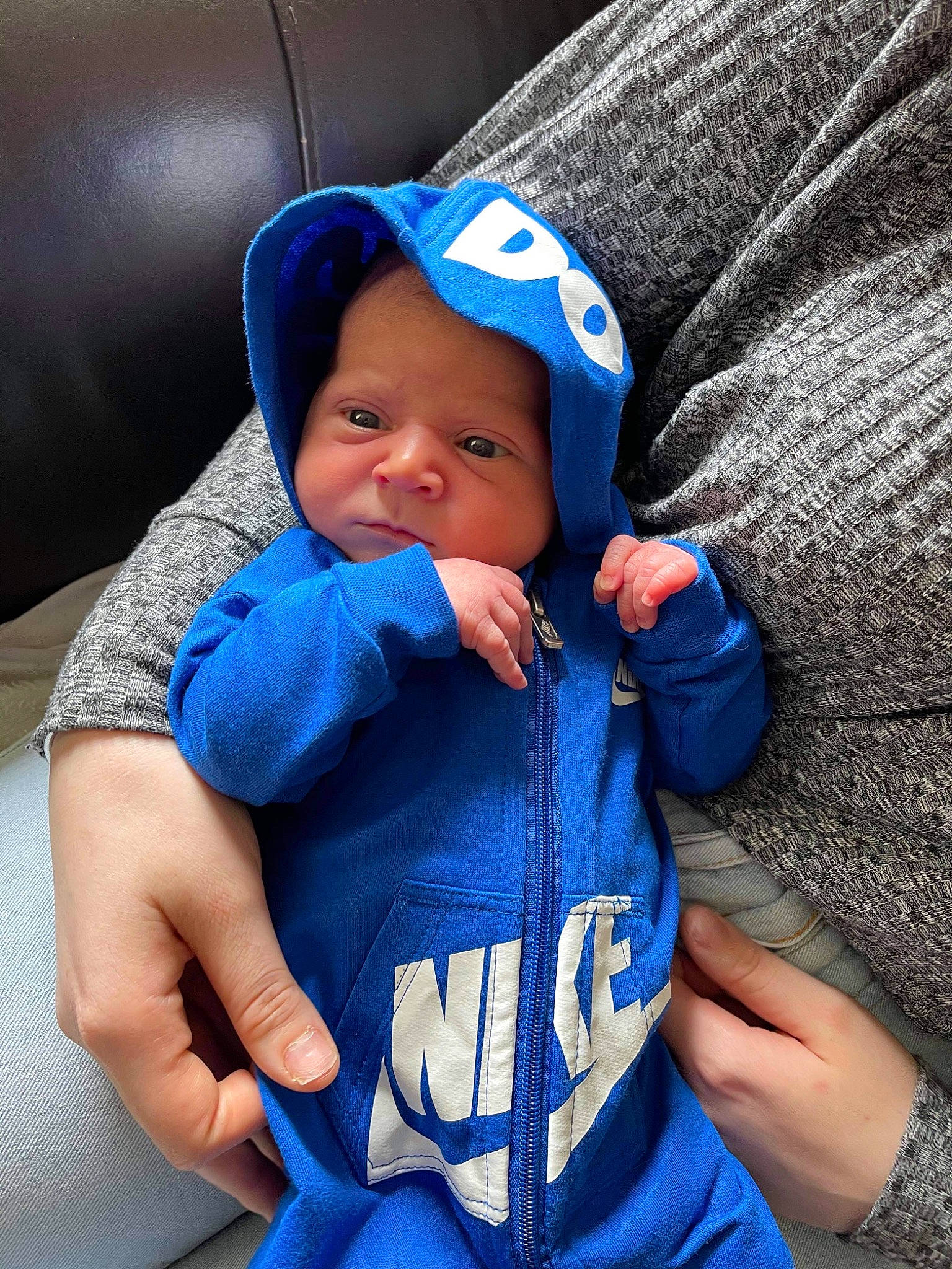 Alistair is registered to the contest to win money with this photo: azure, baby, baby_carriage, baby_toddler_clothing, blue, cap, cheek, comfort, eye, face, finger, gesture, hand, hat, headgear, headwear, human_body, person, purple, skin