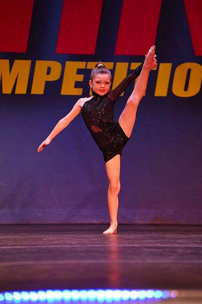 Tenley is registered to the contest to win money with this photo: artist, balance, choreography, competition, competition_event, dance, dancer, electric_blue, entertainment, event, fashion_design, human_leg, knee, one_piece_garment, performance_art, performing_arts, person, public_event, sports, sportswear