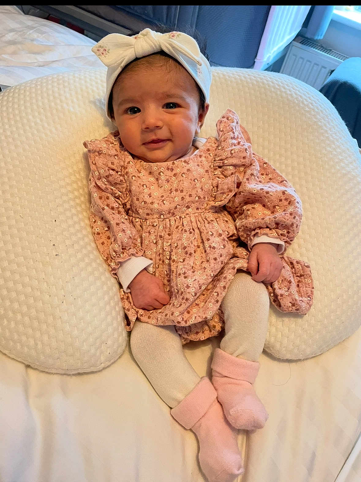 Ayra is registered to the contest to win money with this photo: baby, infant, child, pink_dress, headband, socks, tights, cushion, bed, blanket, indoor, smile, face, hands, legs, cute, portrait, comfort, soft, rest