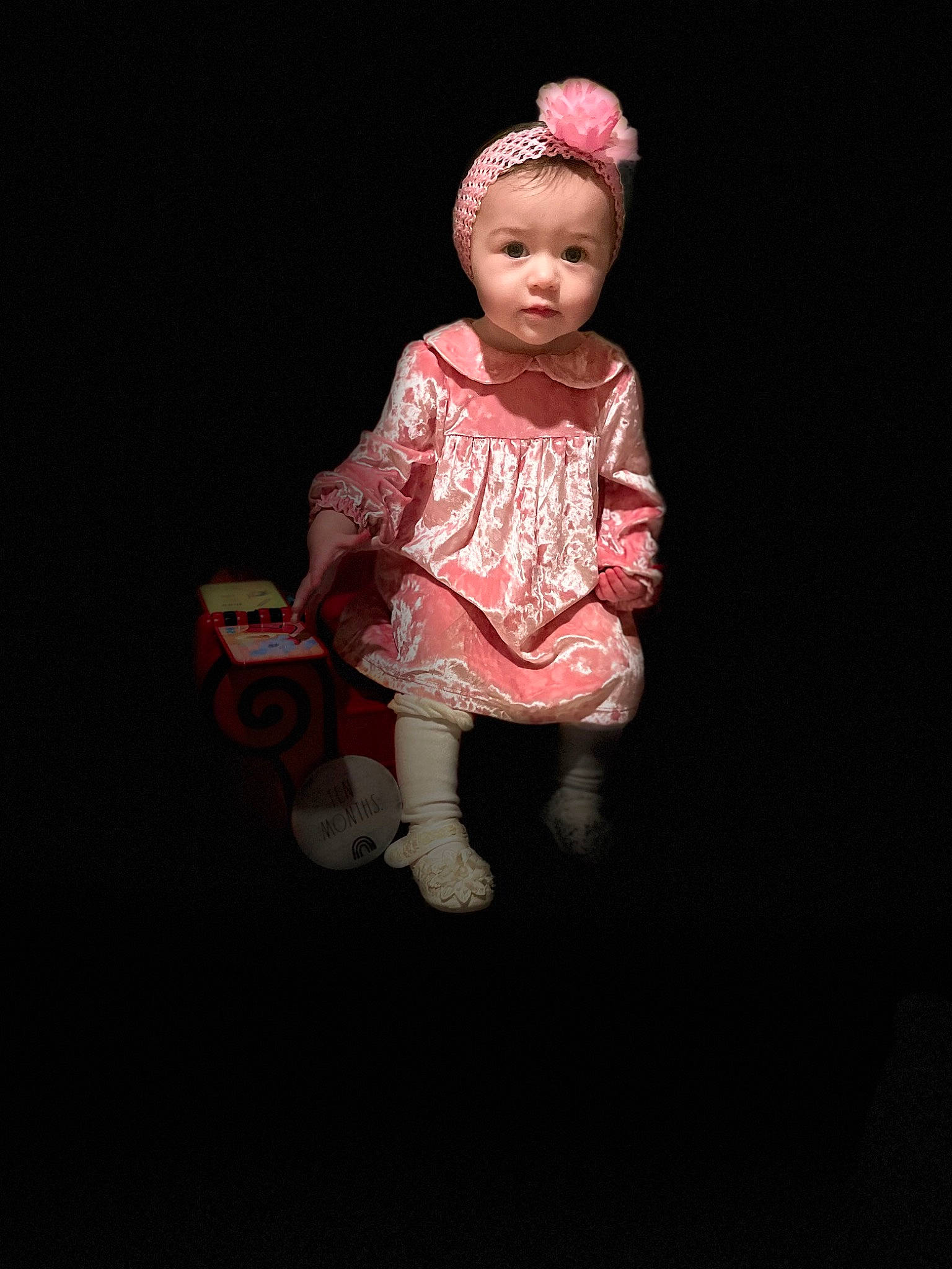 Genevieve is registered to the contest to win money with this photo: baby_toddler_clothing, carmine, cheek, child, darkness, fashion_accessory, flash_photography, flooring, human_leg, lip, magenta, pattern, peach, person, pink, portrait_photography, sitting, sleeve, toddler, toy