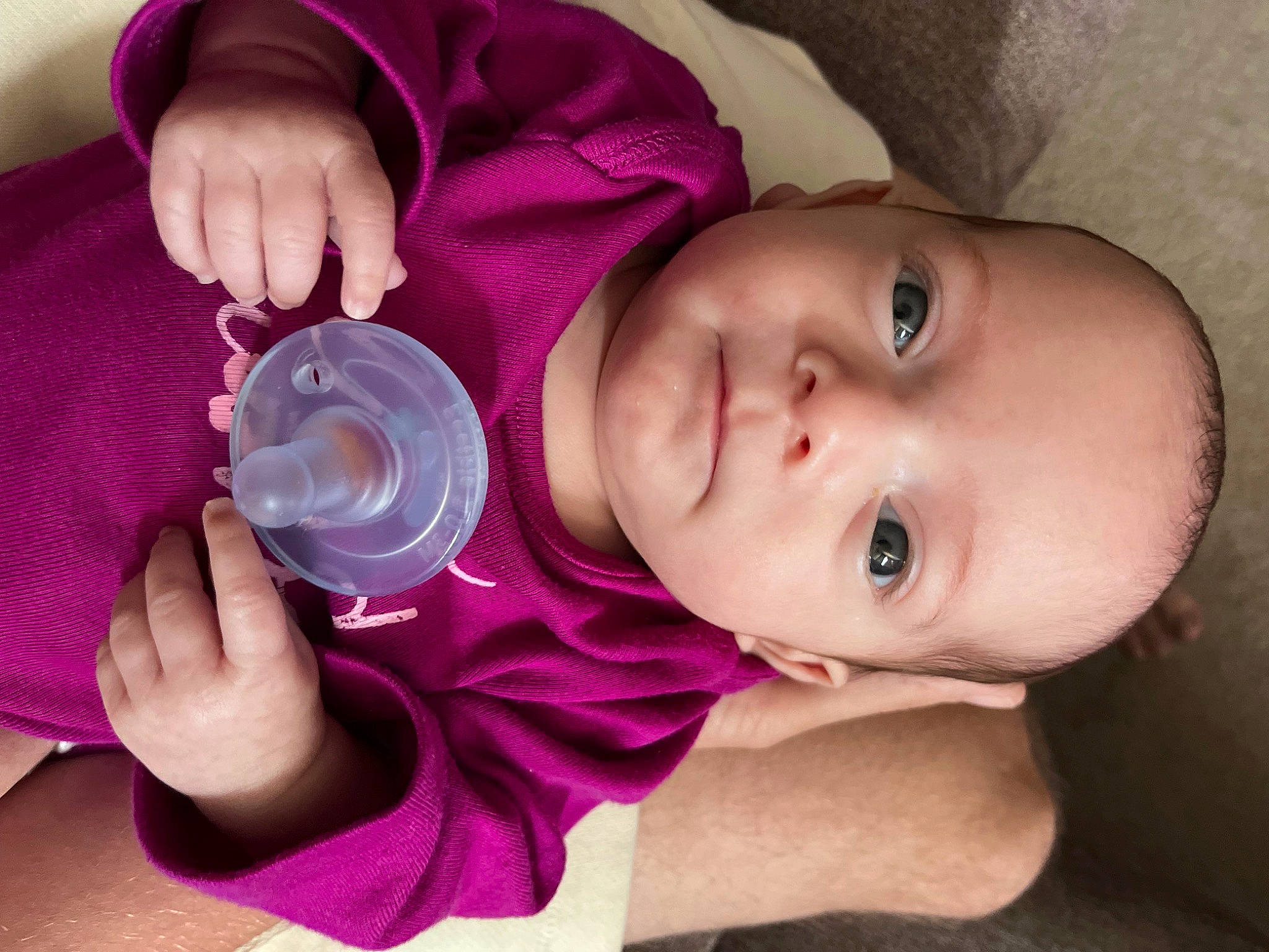 Ariel is registered to the contest to win money with this photo: baby, baby_toddler_clothing, cheek, child, drinkware, eyelash, finger, hand, lip, mouth, nail, nose, person, pink, plastic_bottle, purple, skin, smile, toddler, violet