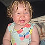 baby, child, smile, curly_hair, dress, butterfly_pattern, sitting, hands, face, happy, cute, indoor, infant, young_child, plush, skin, person, portrait, cheeks, blond_hair