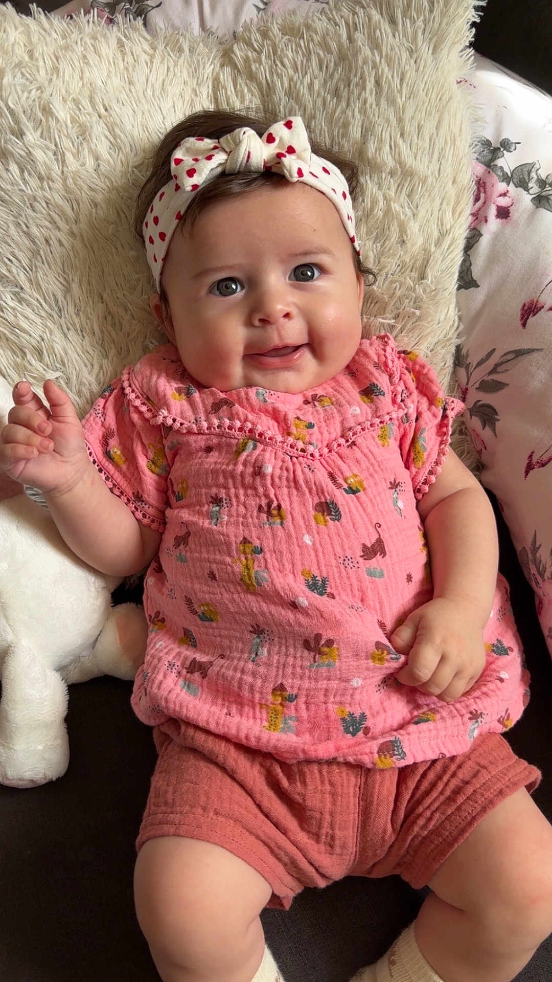 Avélina a rejoint le concours — aidez-le/la à gagner de superbes lots ! baby, child, cozy, cushion, cute, fabric, face, hand, happy, headband, indoor, infant, pillow, pink_clothing, plush_toy, portrait, seated, shorts, smiling, soft_texture