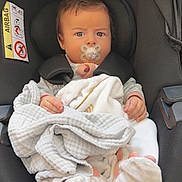 Avélina a rejoint le concours — aidez-le/la à gagner de superbes lots ! baby, blanket, bundle, car_seat, caution_label, child, closeup, clothing, cute, face, footwear, head, indoors, infant, pacifier, person, safety, seatbelt, sitting, young