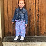 child, smile, denim_jacket, pants, shoes, stone_step, wooden_door, standing, outdoor, happy, person, fashion, casual, portrait, cute, red_hair, clothing, footwear, background, wall