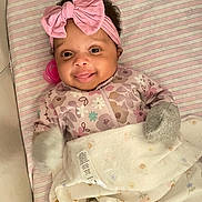 Alexis joined the competition — help win amazing prizes! baby, blanket, child, cozy, cute, floral_pattern, happy, headband, indoors, infant, lying_down, mittens, nursery, pacifier, pink_bow, portrait, sleepwear, smile, soft_toys, striped_mattress