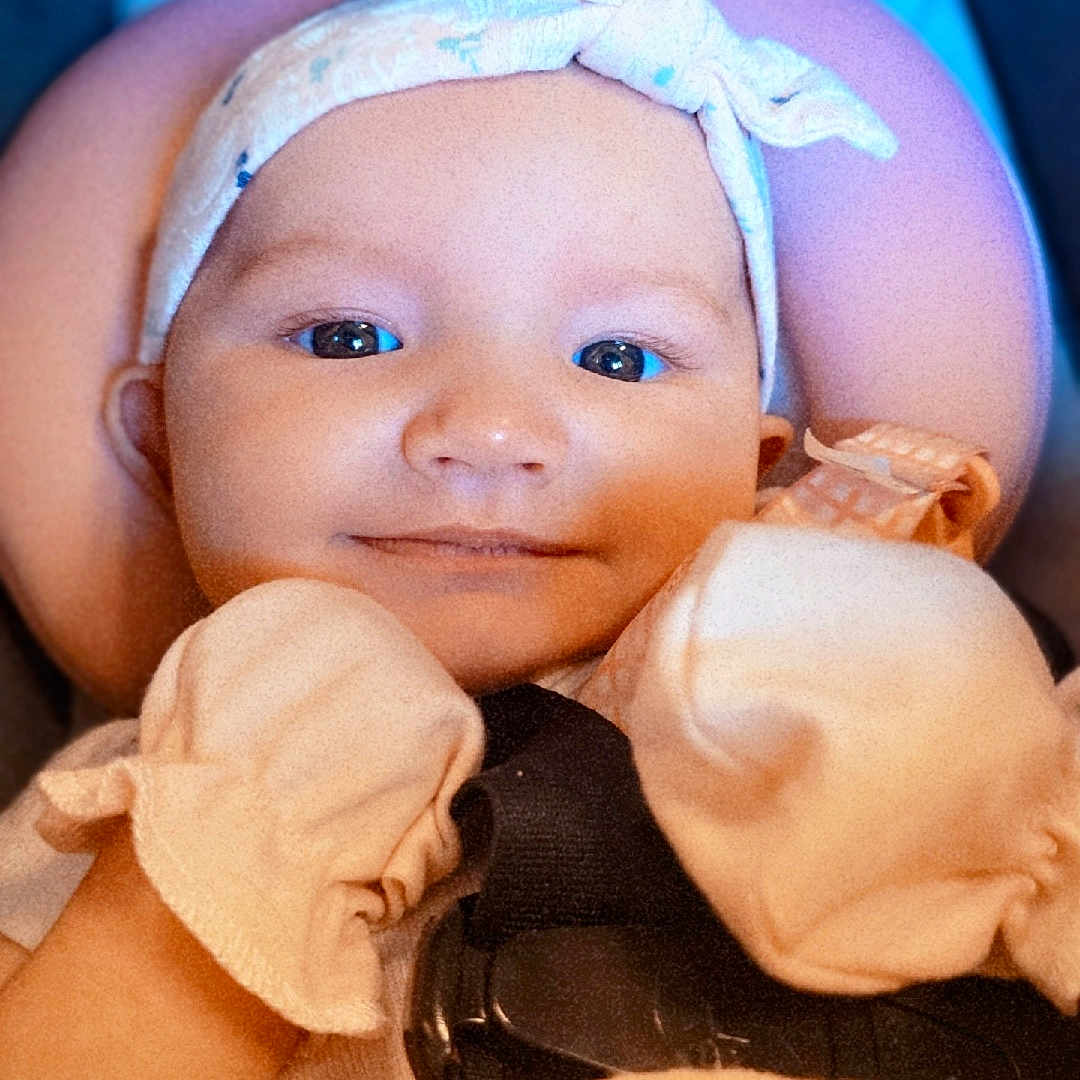 Koralisa is registered to the contest to win money with this photo: baby, blanket, child, closeup, comfortable, cozy, cute, face, happy, head, headband, indoors, infant, mittens, person, portrait, smile, soft, warm, young