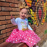 Hope joined the competition — help win amazing prizes! toddler, child, girl, birthday, pink_tutu, polka_dots, bench, brick_wall, graffiti, headband, sneakers, happy, laughing, outdoor, daylight, clothing, fashion, playful, portrait, celebration