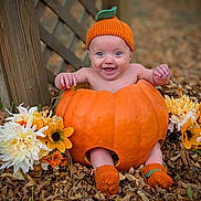 Brixlie is registered to the contest to win money with this photo: baby, pumpkin, hat, knitted, orange, leaves, flowers, autumn, outdoor, cute, smiling, sitting, child, seasonal, nature, fall, happy, footwear, wood, background