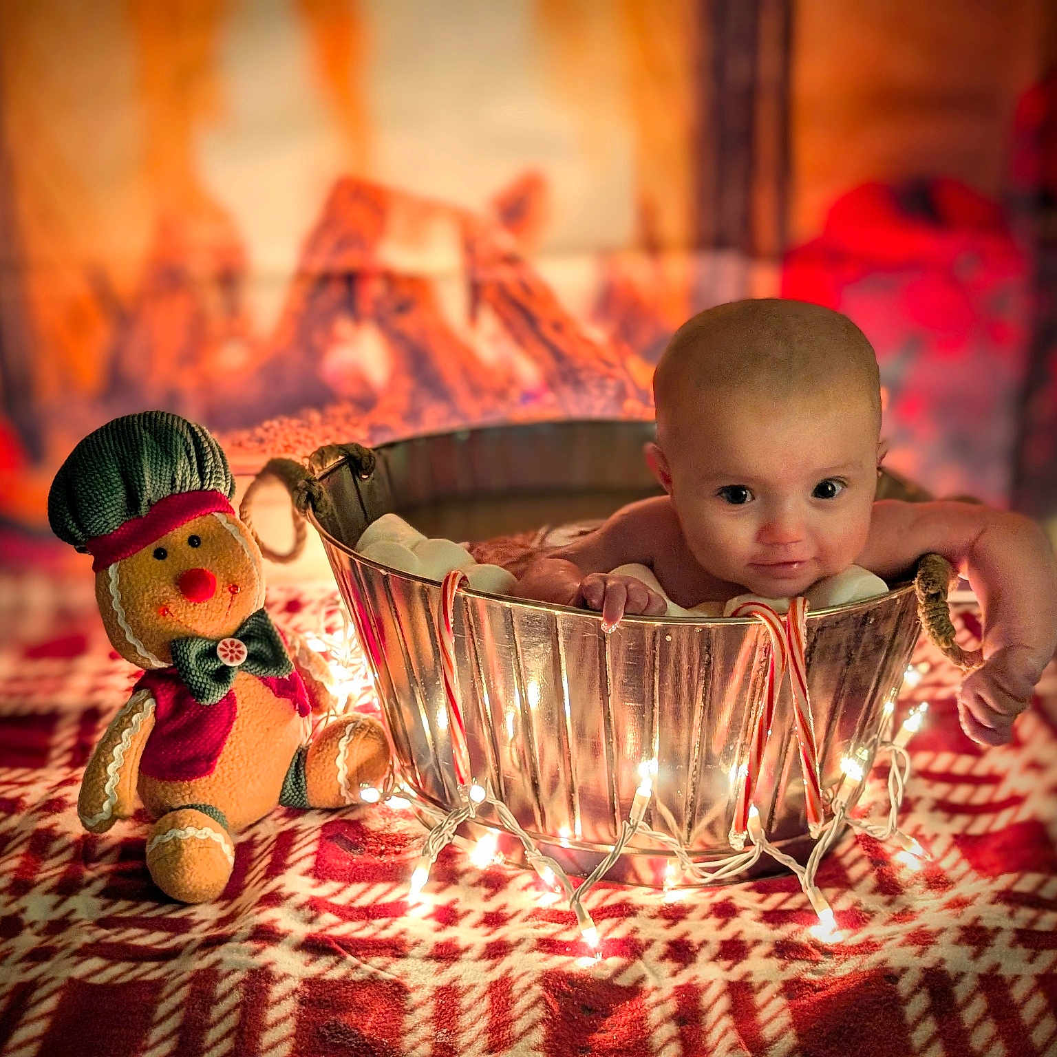 Brixlie is registered to the contest to win money with this photo: baby, blanket, candy_canes, christmas, cozy, cute, decor, festive, fireplace, gingerbread_plush, green, holiday, indoor, infant, metal, red, smile, string_lights, tub, warm