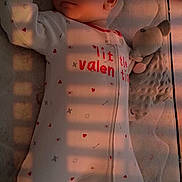 Tiana is registered to the contest to win money with this photo: baby, sleeping, onesie, soft_toy, mattress, shadow, striped_light, indoor, peaceful, child, infant, cute, cozy, bedtime, warm_light, relaxation, toddler, sleep, comfort, nursery