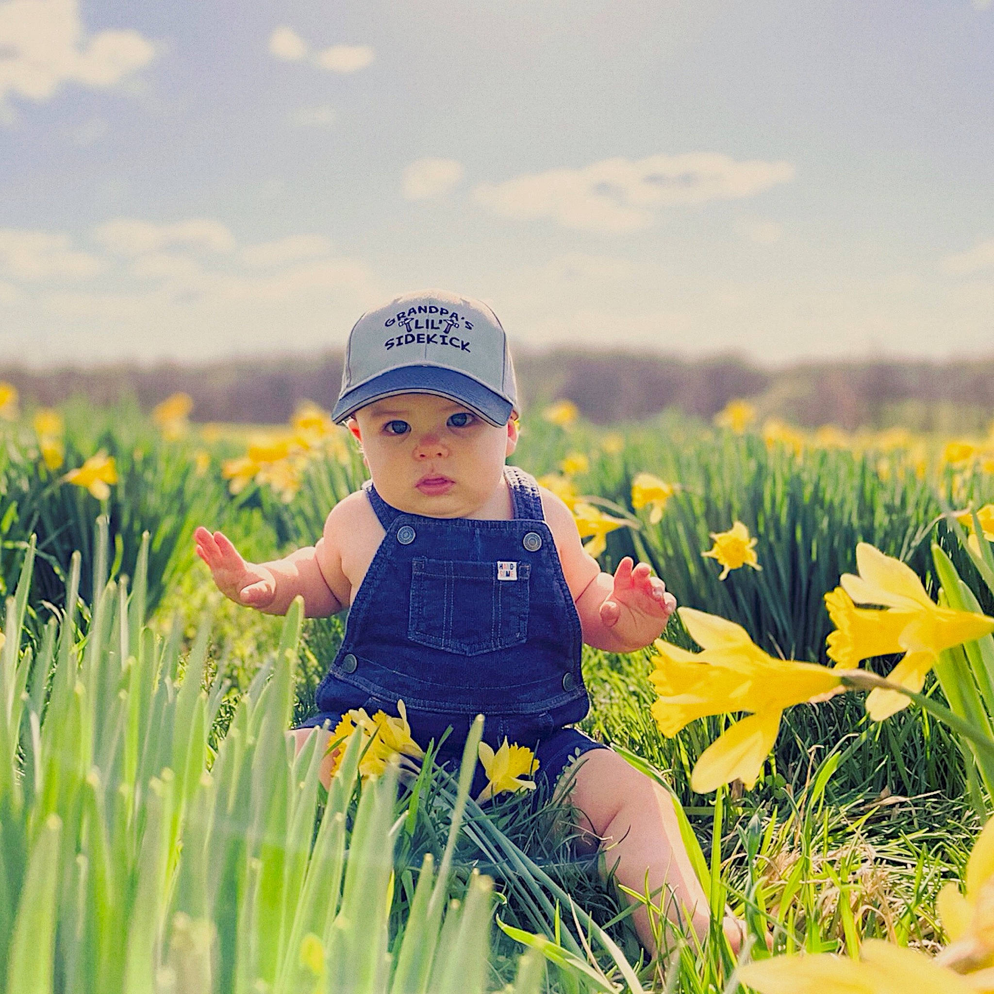 Greysen joined the competition — help win amazing prizes! baby, baby_toddler_clothing, cloud, flower, grass, grass_family, grassland, happy, hat, headwear, landscape, leaf, meadow, natural_environment, nature, people_in_nature, person, plant, sky, sunlight