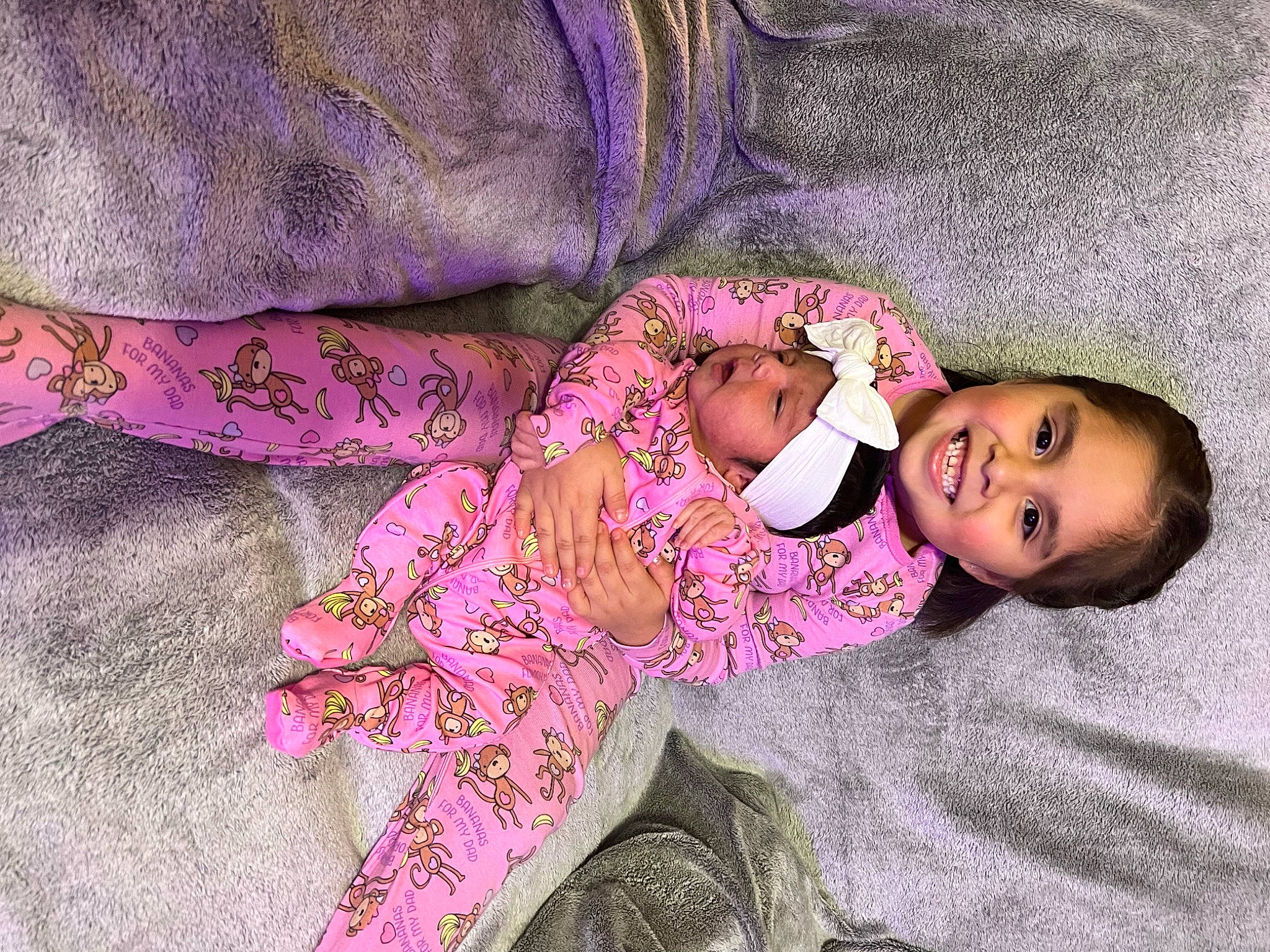 Anniston is registered to the contest to win money with this photo: arm, baby, baby_sleeping, baby_toddler_clothing, child, comfort, eye, head, headwear, human_body, joy, linens, magenta, pattern, person, pink, product, purple, skin, sleeve