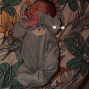Lilou participe au concours pour gagner de l'argent avec cette photo : baby, sleeping, onesie, infant, blanket, patterned_blanket, animal_face, floral_pattern, leaves, cozy, cute, child, peaceful, resting, indoors, soft_lighting, portrait, person, newborn, lying_down