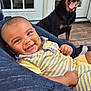 Grayson joined the competition — help win amazing prizes! baby, candid, cozy, dog, door, face, glass_panes, happy, infant, joyful, knit_blanket, outdoor, person, pet, rottweiler, smile, striped_clothing, tongue_out, wooden_deck, yellow_clothing