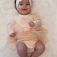 Amélia a rejoint le concours — aidez-le/la à gagner de superbes lots ! baby, infant, smiling, headband, tutu, peach_outfit, lying_down, blanket, cute, happy, chubby_legs, soft_texture, portrait, child, adorable, infant_clothing, baby_girl, close_up, indoors, cozy