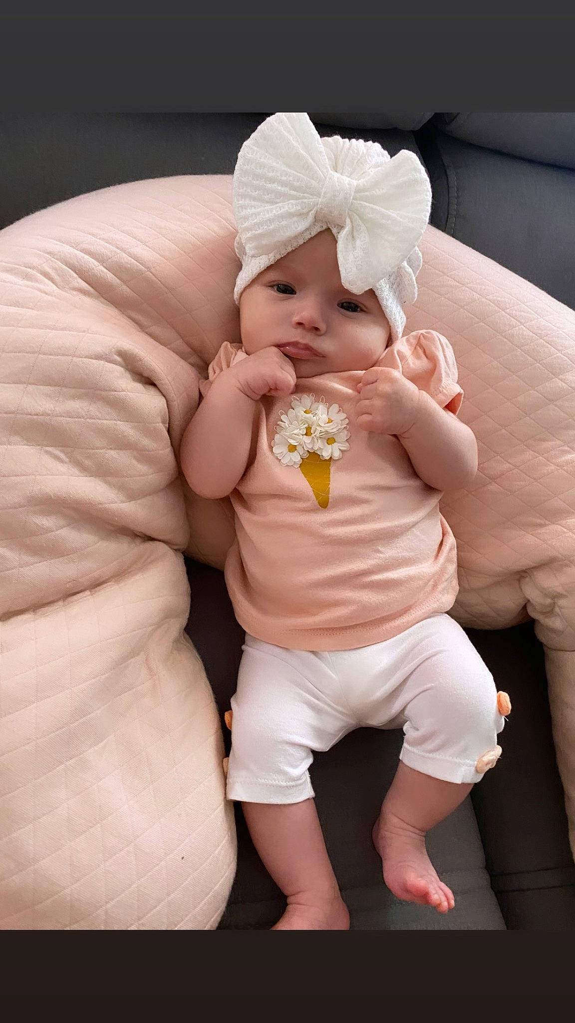 Leïla participe au concours pour gagner de l'argent avec cette photo : abdomen, baby, baby_products, baby_sleeping, baby_toddler_clothing, comfort, couch, face, flash_photography, foot, happy, headgear, headwear, human_leg, linens, nail, person, pink, sitting, skin