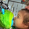 Eugene joined the competition — help win amazing prizes! toddler, child, stuffed_toy, plush, green, blue, face, profile, indoor, curly_hair, scrunchie, hand, soft_toy, close_up, baby, portrait, playtime, candid, cute, exploration