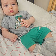 Adam joined the competition — help win amazing prizes! baby, child, infant, bed, bedding, tshirt, shorts, socks, face, hand, wooden_crib, home_interior, pillow, sleepwear, resting, cute, portrait, indoor, person, casual_clothing