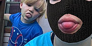 Wrangler is registered to the contest to win money with this photo: balaclava, blue_shirt, casual_clothing, child, daylight, door, expression, funny_face, glass, house, mask, outdoor, person, playful, portrait, shorts, sticking_tongue, tongue_out, window, wood
