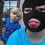 balaclava, blue_shirt, casual_clothing, child, daylight, door, expression, funny_face, glass, house, mask, outdoor, person, playful, portrait, shorts, sticking_tongue, tongue_out, window, wood