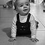 baby, child, infant, crawling, pigtails, black_and_white, floor, tile, curious, indoors, cat, pet, blurred_background, long_sleeve_shirt, overalls, cute, portrait, hands, expression, home