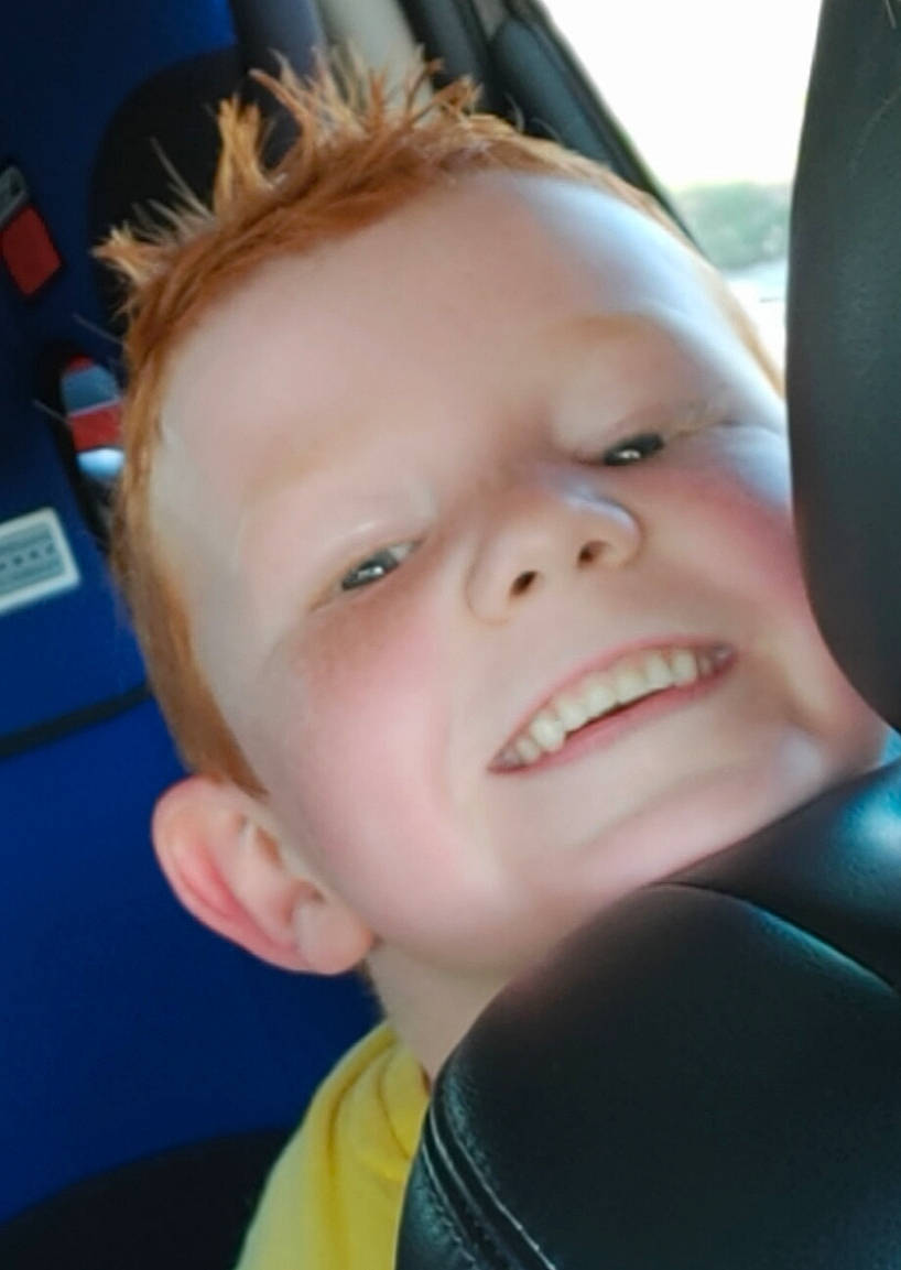 Jake is registered to the contest to win money with this photo: car_seat, cheek, child, chin, cool, ear, eye, face, facial_expression, forehead, fun, hair, hairstyle, head, lip, mouth, nose, person, skin, smile