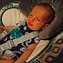 baby, infant, child, pacifier, baby_seat, seatbelt, clothing, pattern, daisy, cushion, fabric, person, face, arm, headrest, indoors, resting, cute, sleepy, comfort