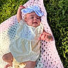 baby, child, infant, grass, blanket, crochet, headband, bow, dress, yellow, pink, white, outdoor, sunlight, smiling, happy, reaching, skin, legs, hands