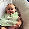 Paisley is registered to the contest to win money with this photo: baby, child, infant, face, tongue, bib, pink_clothing, baby_seat, cushion, smile, happy, skin, hand, sitting, indoor, cute, young_child, portrait, expression, playful