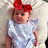 Paisley is registered to the contest to win money with this photo: baby, infant, red_bow, headband, striped_outfit, blue_and_white, stars, pillow, white_pillow, lying_down, curious_expression, wide_eyes, indoor, portrait, cute, small_hands, soft_lighting, close_up, child, person