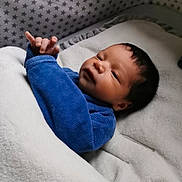 Ezio a rejoint le concours — aidez-le/la à gagner de superbes lots ! baby, blanket, blue_clothing, crib, face, hand, infant, indoors, laying_down, newborn, person, plush, reaching_hand, sleeping_area, soft_texture, star_pattern, toddler, young_child, cozy, wrapped