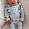baby, infant, smiling, pajamas, striped_clothing, duck_print, cozy, soft_blanket, white_blanket, lying_down, happy, child, cute, portrait, indoor, comfortable, small_hands, footed_pajamas, head, face