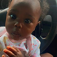 Nariyah is registered to the contest to win money with this photo: adorable, baby, car_seat, child, clothing, curly_hair, cute, expression, eyes, face, hands, head, indoor, infant, onesie, person, portrait, seated, skin, young