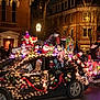 building, car, celebration, christmas_lights, crowd, decoration, dog, festive, float, hat, holiday, light, night, parade, people, reindeer, snowman, street, tree, window