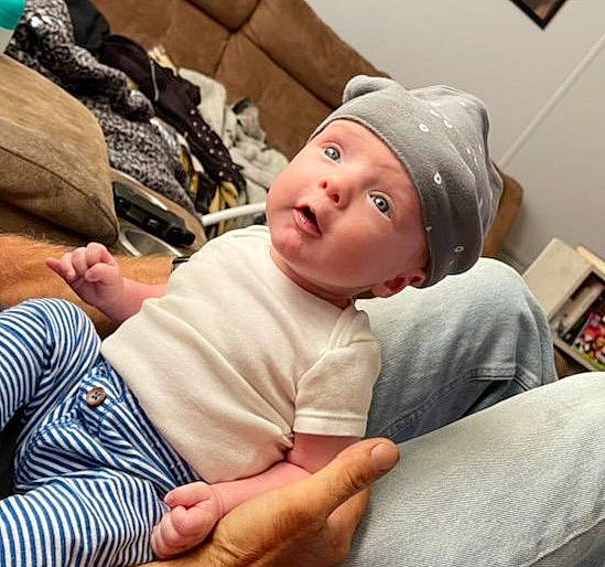 Kane joined the competition — help win amazing prizes! abdomen, baby, baby_toddler_clothing, cheek, child, comfort, elbow, finger, fun, gesture, happy, headwear, linens, mammal, mouth, person, pillow, sitting, t_shirt, toddler