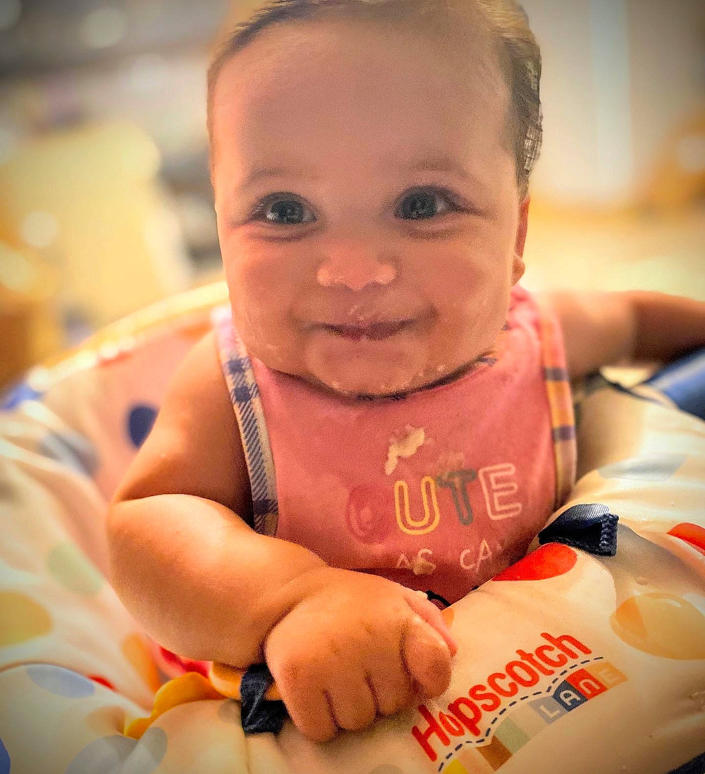 Cadence is registered to the contest to win money with this photo: baby, baby_products, baby_toddler_clothing, cheek, child, dress, event, finger, fun, hand, happy, head, iris, nail, nose, orange, person, sitting, skin, smile