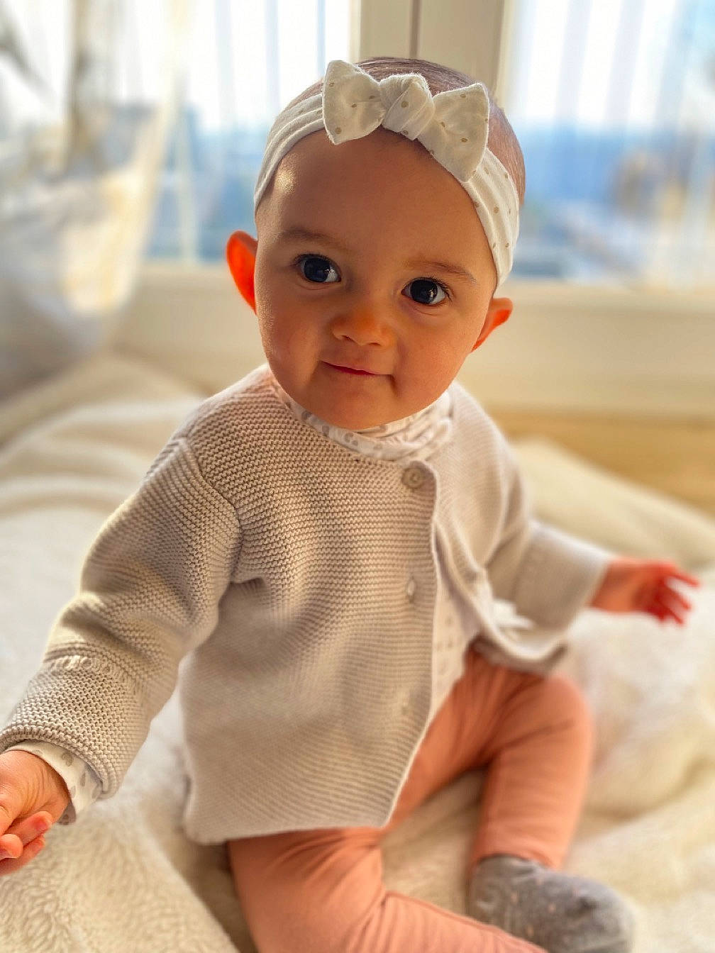 Eva a rejoint le concours — aidez-le/la à gagner de superbes lots ! baby, baby_toddler_clothing, cap, cheek, child, comfort, eye, face, fashion_accessory, flooring, happy, iris, lip, person, pink, sitting, skin, sleeve, smile, toddler