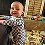 Lucas joined the competition — help win amazing prizes! baby, child, checkered_onesie, smile, standing, table, living_room, fireplace, play_mat, toy_car, toy, floor, carpet, person, indoor, cute, happy, infant, home, playtime