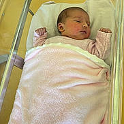 élyne a rejoint le concours — aidez-le/la à gagner de superbes lots ! newborn, baby, blanket, pink, hospital, bassinet, sleeping, infant, child, soft, face, resting, peaceful, wrapped, clothing, person, skin, head, indoors, yellow_background