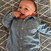 Lyam participe au concours pour gagner de l'argent avec cette photo : baby, child, denim_shirt, jeans, smiling, happy, lying_down, carpet, patterned, casual_clothing, cute, infant, playful, portrait, indoor, young_child, buttoned_shirt, short_hair, blue_clothing, human